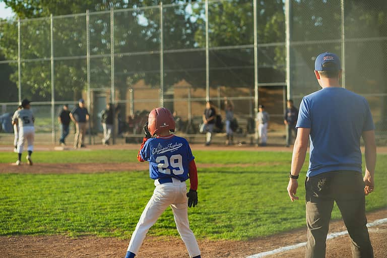 youth baseball player on third base who is covered bu youth travel baseball team insurance