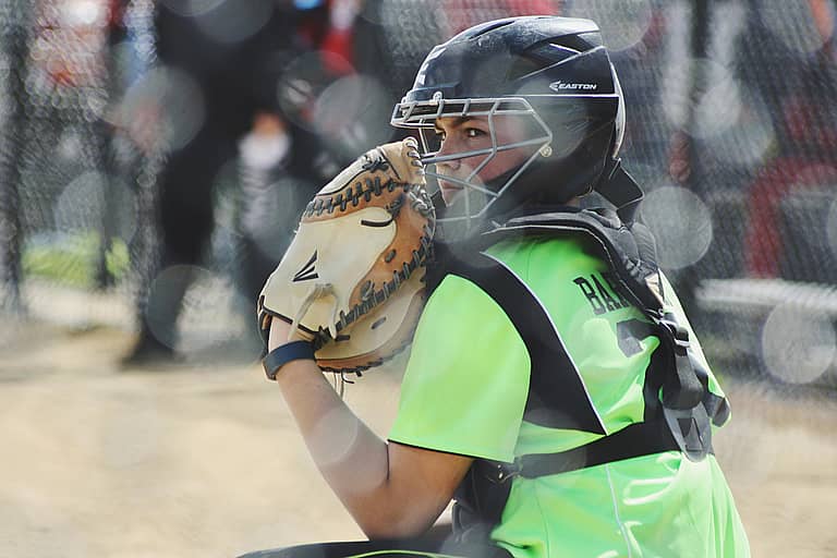youth softball catcher in image for article "how much is insurance for a travel softball team"